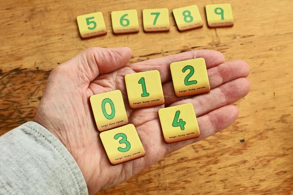 Five teign digit cards held on an open adult hand